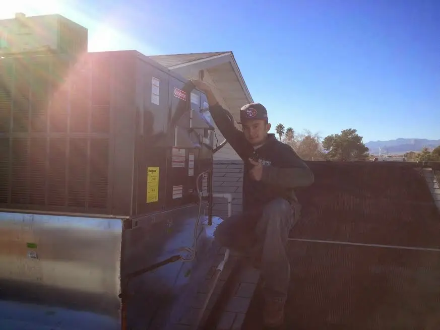 HVAC technician performing AC Tune-Up on a rooftop unit in Fortuna